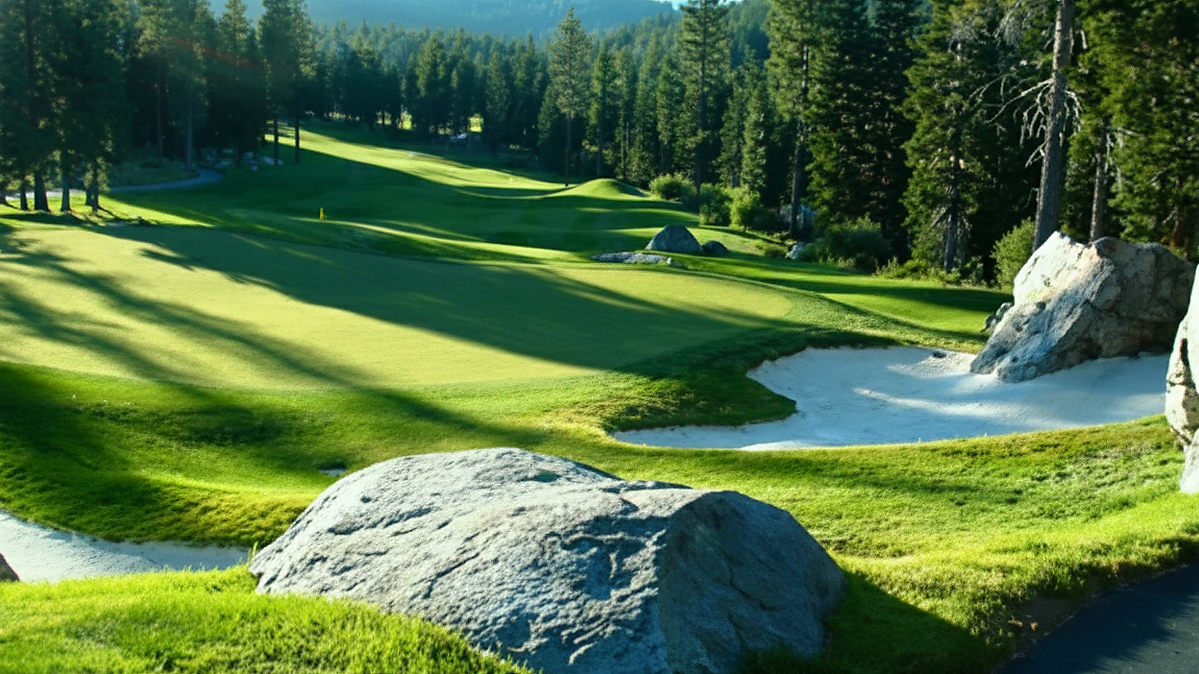 Aerial view of a golf course winding through pines at dusk